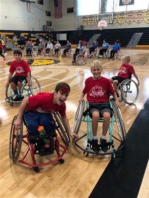 students seated in wheelchairs smile