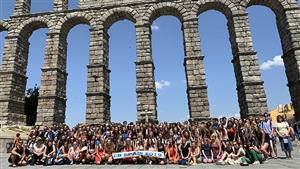 students pose before an aqueduct in spain 