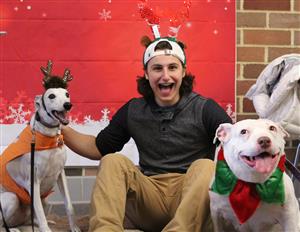 student poses with therapy dogs 