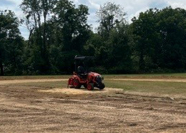 a tractor turns a field over the summer