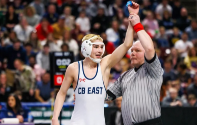  Chase's arm is raised in victory by a referee.