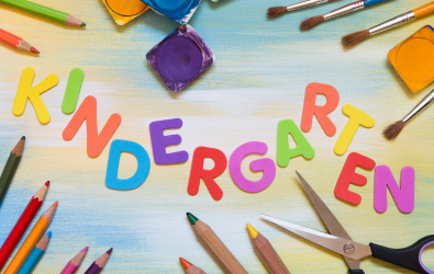  The word "Kindergarten" spelled out in letter magnets on a classroom desk.