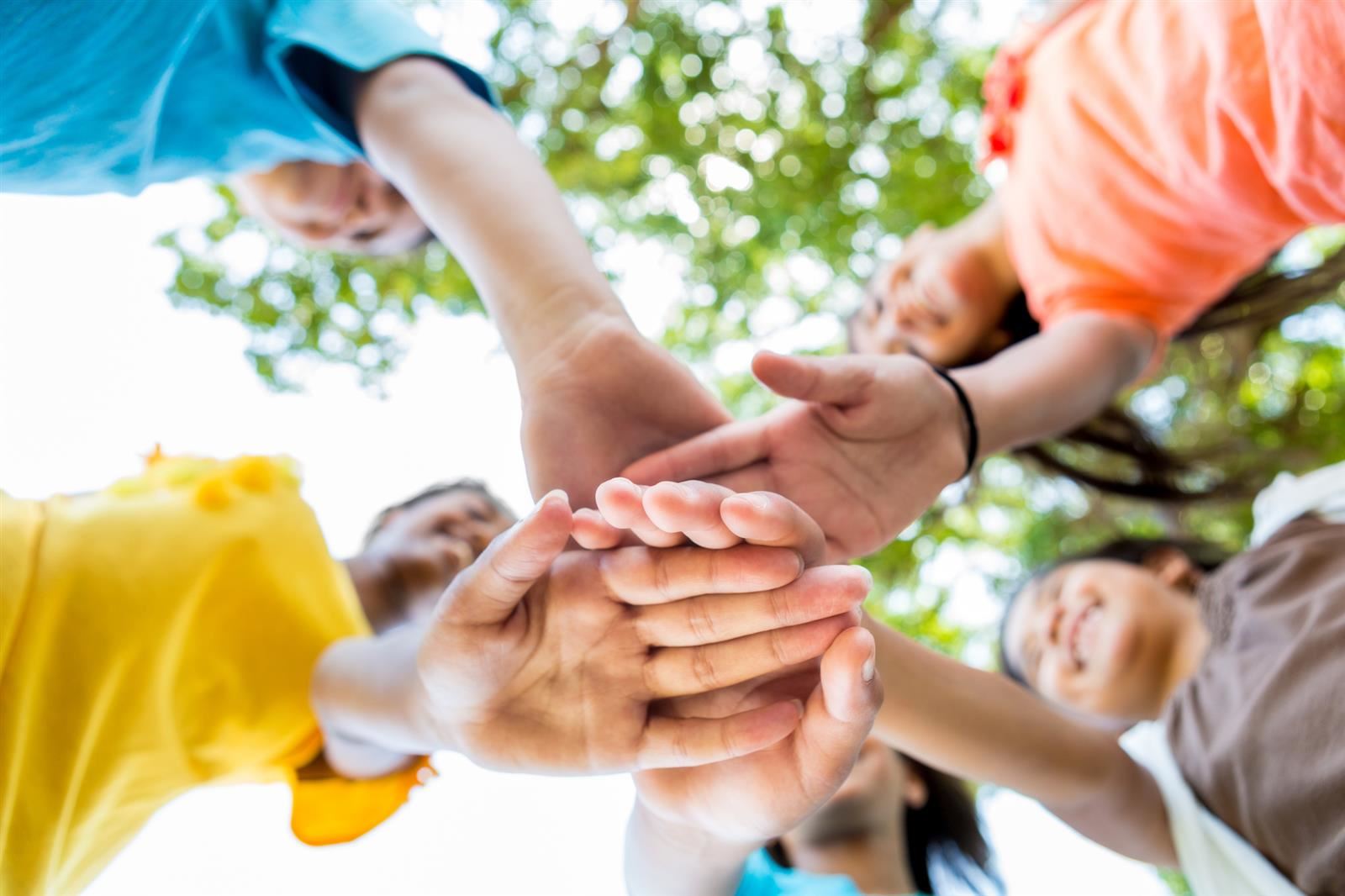 Kids put their hands together about to celebrate