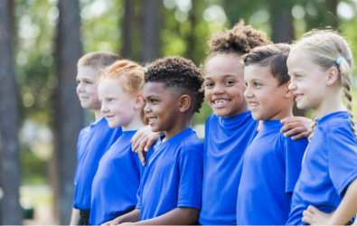  Kids arm in arm in a line smiling.