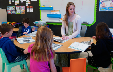  A high school student helps younger students with reading.